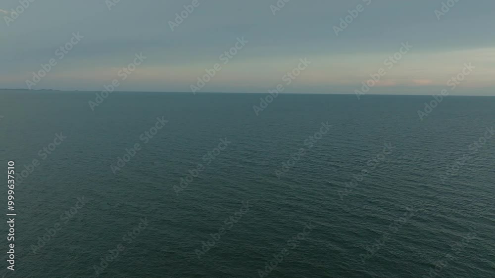 Calm Overcast Morning at the Serene Ocean With Gentle Waves Lapping at the Shoreline Calm Overcast Morning at the Serene Ocean With Gentle Waves Lapping at the Shoreline