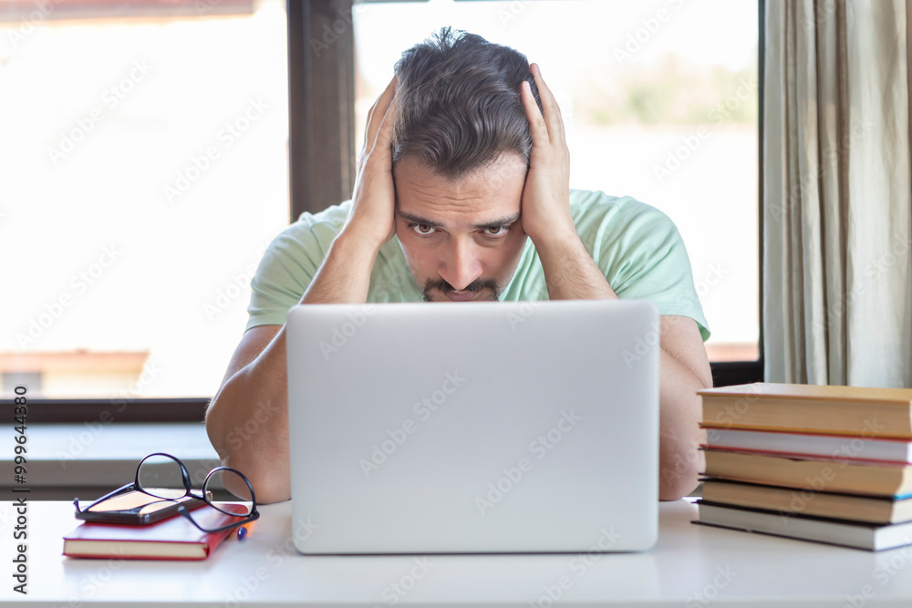Tired and bored student sitting at the desk while preparing for exams at university Tired and bored student sitting at the desk while preparing for exams at university