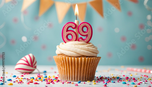 Birthday cupcake with burning lit candle with number 69. Number sixty-nine for sixty-nine years or sixty-ninth anniversary. photo