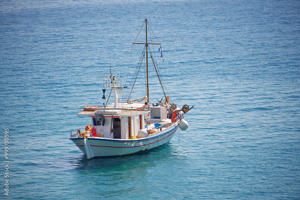 A greek fishing boat in the middle of the blue sea A greek fishing boat in the middle of the blue sea