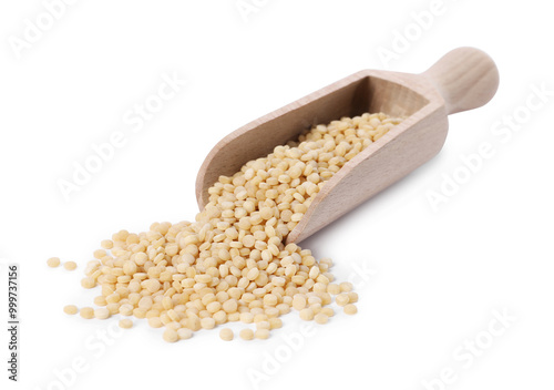 Raw couscous in wooden scoop isolated on white