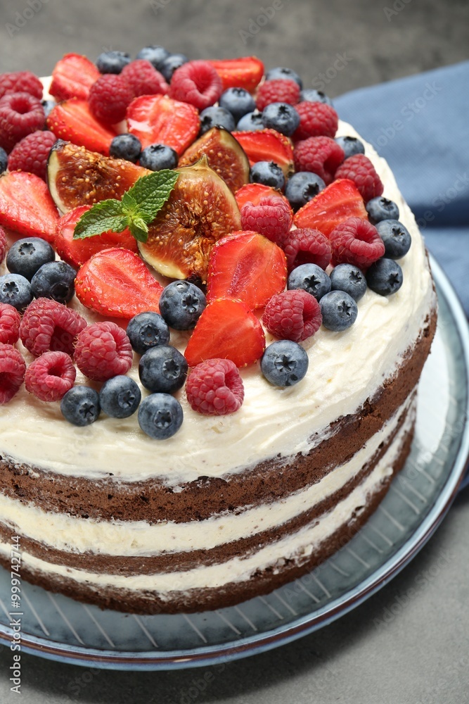 Delicious chocolate sponge cake with berries on grey table, closeup Delicious chocolate sponge cake with berries on grey table, closeup