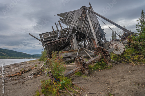 Remains of a paddle wheel from a riverboat wreck on the banks of the Yukon River at Dawson City, Yukon, Canada