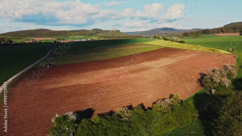 A breathtaking aerial view of rural USA in springtime, showcasing lush meadows, forests, and agricultural fields under a vibrant sky. Idyllic, peaceful, and full of natural beauty.