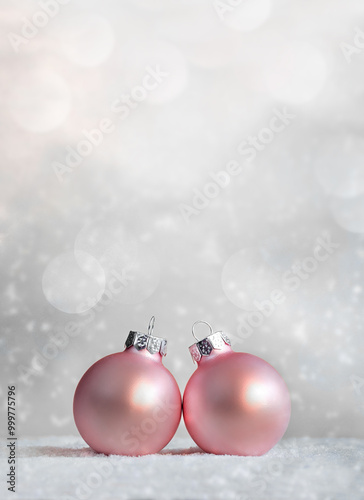 Beautiful pink Christmas balls, snowflakes on snow on winter background.