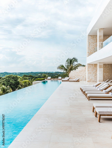 Luxurious infinity pool overlooking lush greenery at a modern villa during a cloudy day