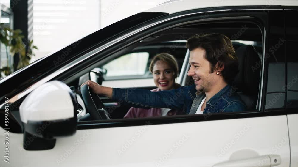 A couple examines options for a new family car in a modern showroom. Their careful selection reflects the importance of finding a vehicle that meets both lifestyle needs and family comfort. A couple examines options for a new family car in a modern showroom. Their careful selection reflects the importance of finding a vehicle that meets both lifestyle needs and family comfort.