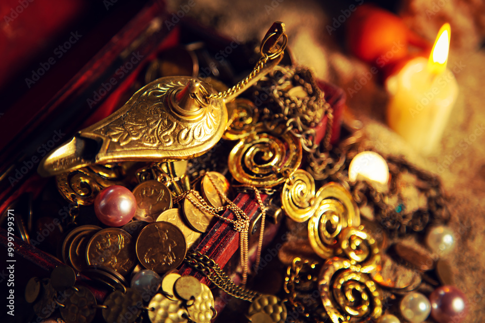 Fototapeta premium Precious golden magic lamp and treasure chest on sand.
