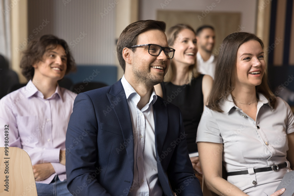 Happy cheerful audience of managers attending conference, meeting, training, seminar, sitting in rows in corporate hall, listening to coach, leader, speaker, laughing, getting knowledge Happy cheerful audience of managers attending conference, meeting, training, seminar, sitting in rows in corporate hall, listening to coach, leader, speaker, laughing, getting knowledge