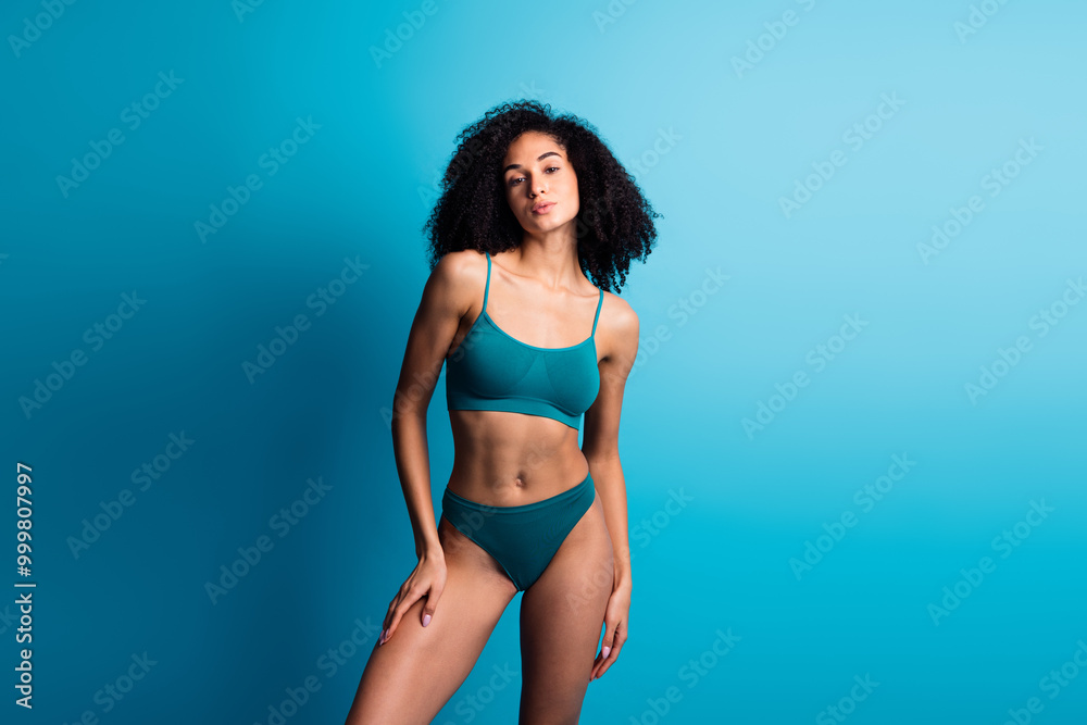 Photo portrait of attractive young woman posing touch legs hips dressed cyan lingerie no filter isolated on blue color background Photo portrait of attractive young woman posing touch legs hips dressed cyan lingerie no filter isolated on blue color background