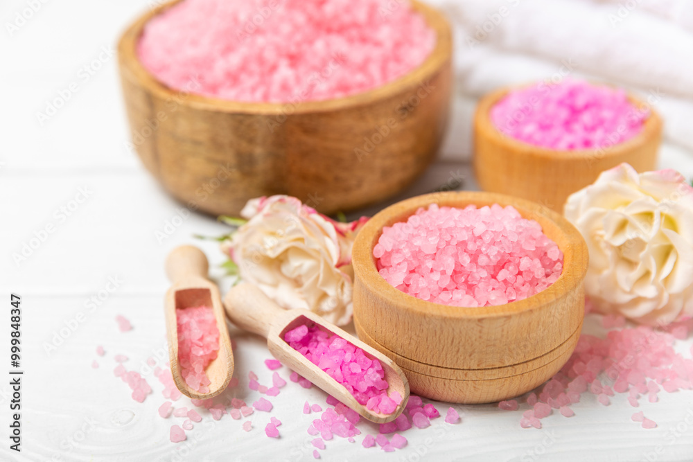 Sea salt for bath with aroma and rose flowers on textured wooden background. Pink sea salt. Spa treatments. Natural salt with herbs and essential oils. skincare concept. Meso for text. Copy space Sea salt for bath with aroma and rose flowers on textured wooden background. Pink sea salt. Spa treatments. Natural salt with herbs and essential oils. skincare concept. Meso for text. Copy space