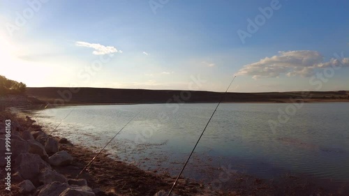 A fisherman who puts on a bell, casts his fishing rod into the lake and catches fish,