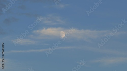 close up view of the moon during the day,full moon view of the moon on a blue and cloudy day,
