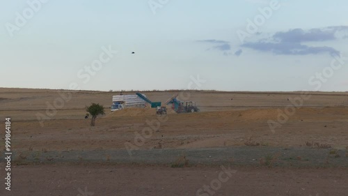workers loading hay onto the truck, general shot of workers working