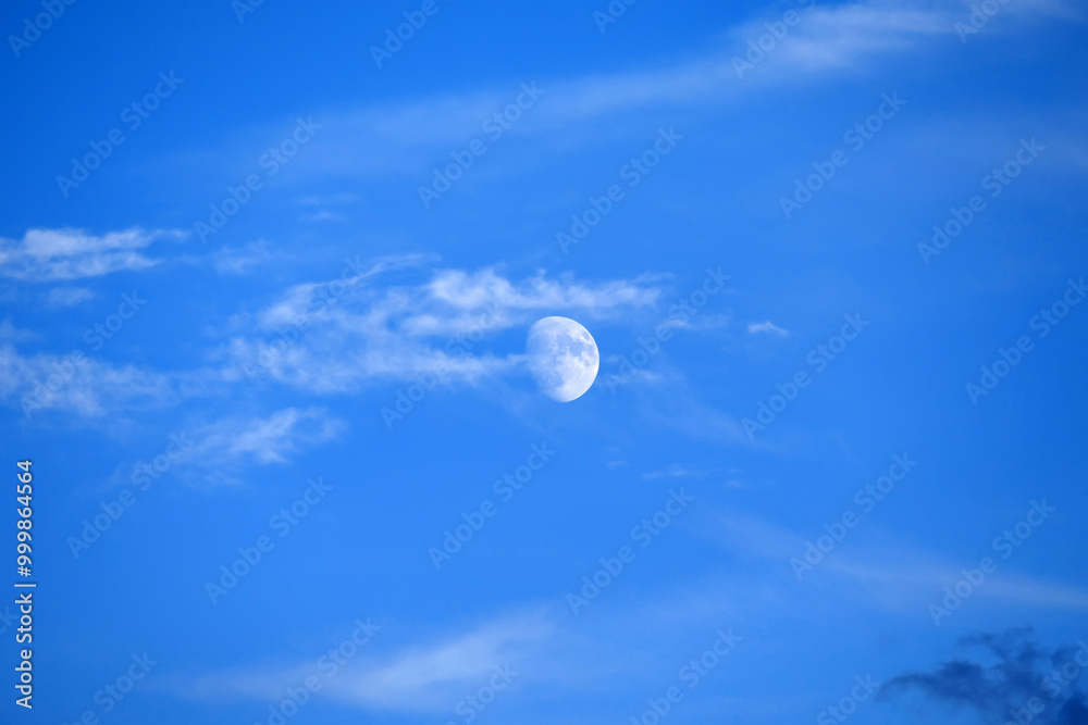 close up view of the moon during the day,full moon view of the moon on a blue and cloudy day