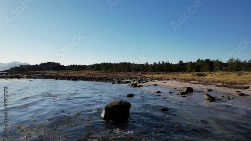 Küste einer Norwegischen Insel mit Gebirge im Hintergrund photo