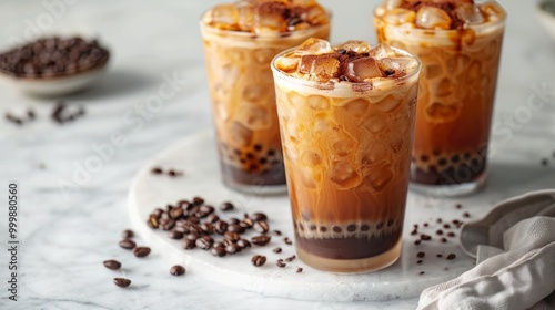 Iced tapioca coffee latte or boba pearl bubbles milk tea, asian trendy cold coffee drink with tapioca balls and crushed ice, on white marble background copy space 