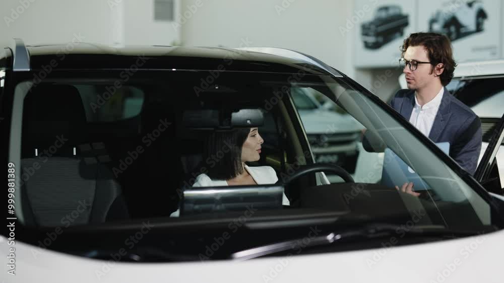 A confident car dealer discusses discounts and benefits of a new car with the buyer. This exchange highlights the excitement of buying and test-driving a new car. A confident car dealer discusses discounts and benefits of a new car with the buyer. This exchange highlights the excitement of buying and test-driving a new car.