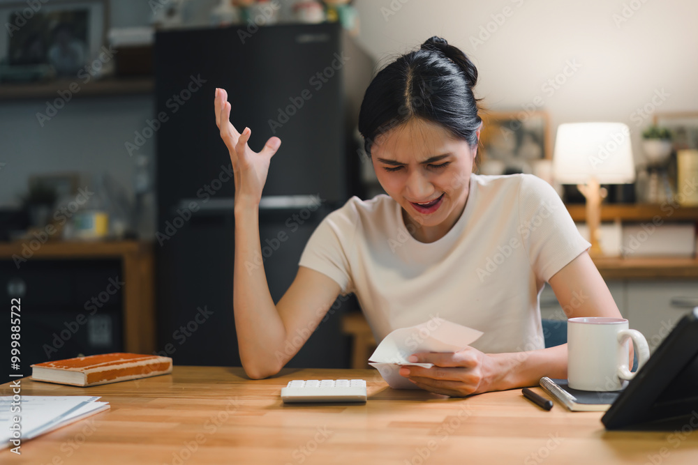 Frustration businesswoman while reviewing her finances at home. She holds paper and uses a calculator, capturing the stress of budgeting and expenses. Frustration businesswoman while reviewing her finances at home. She holds paper and uses a calculator, capturing the stress of budgeting and expenses.