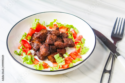 a plate of chopped beef steak with salad