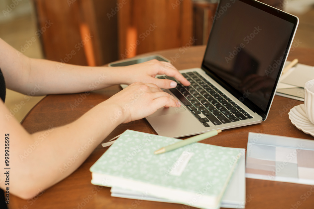 Close-up of a woman sitting at a desk using her laptop computer