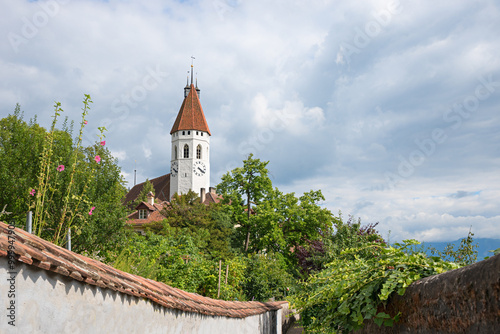 view to historic city church Thun and castle wall, green shrubs. swiss landscape photo