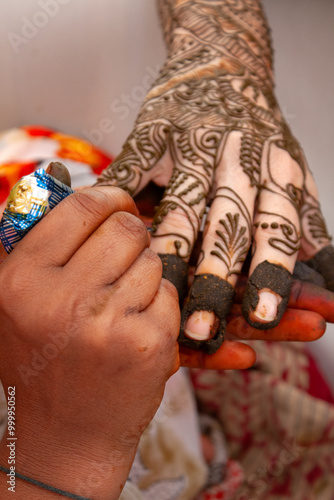 Close-up of a Henna tattoo (mehendi) being applied to a woman's hand before an Indian wedding photo