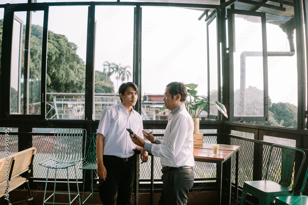 Two Southeast Asian men engaging in an enthusiastic conversation Two Southeast Asian men engaging in an enthusiastic conversation