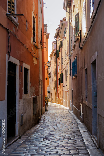 Charming cobblestone alleyway in Rovinj, Croatia, illuminated by the warm glow of evening light