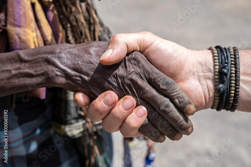 Black and white human hand shake in small village, Danakil depression, Afar region, Ethiopia
