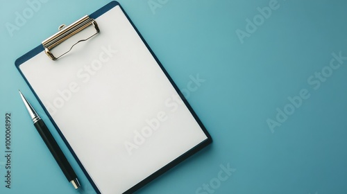 Blank clipboard and pen on blue background, ready for notes and organizationa...