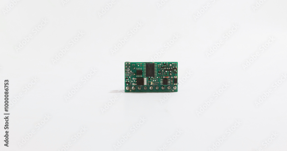 Close up of small electronic circuit board with components on plain white background.