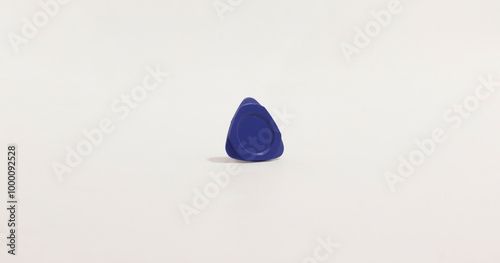 Minimalist photo of small, blue, triangular phone pry tool with circular center on plain white background. photo