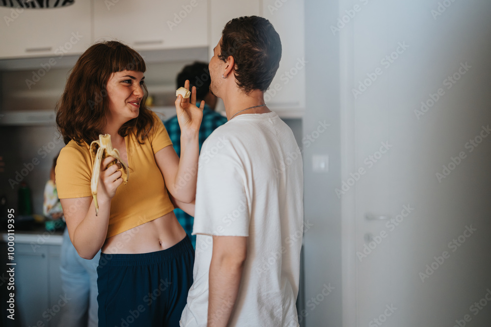 A cheerful young couple enjoys a playful moment with bananas in a modern kitchen, symbolizing joy and connection in everyday life. A cheerful young couple enjoys a playful moment with bananas in a modern kitchen, symbolizing joy and connection in everyday life.