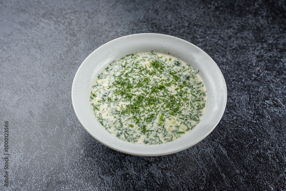 A white bowl of soup with parsley on top A white bowl of soup with parsley on top