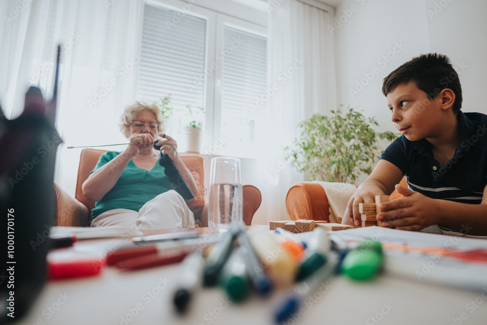 A grandmother enjoys knitting a vest for her nephew while he plays with building blocks, highlighting family bonding and cozy home activities. The scene captures warmth, creativity, and togetherness. A grandmother enjoys knitting a vest for her nephew while he plays with building blocks, highlighting family bonding and cozy home activities. The scene captures warmth, creativity, and togetherness.