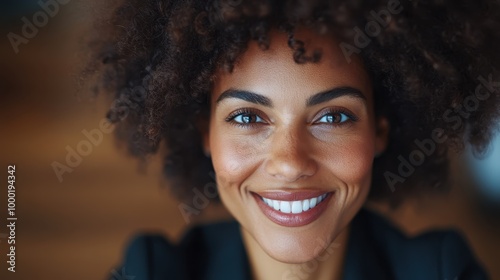 A candid close-up of a confident woman with natural curls and a warm, welcoming smile, conveying warmth, self-assurance, and a lively, optimistic spirit.