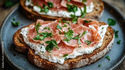 Open-face sandwich with finely sliced ham and a spread of cream cheese, garnished with chopped herbs on crusty bread, perfect for a tasty meal or snack. photo