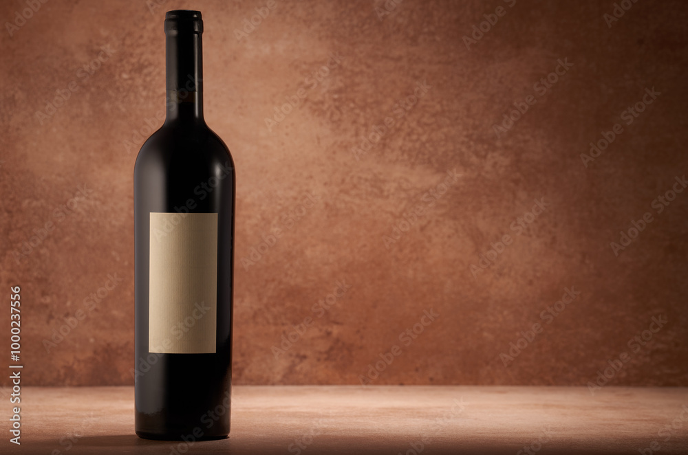 Fototapeta premium Wine bottle on orange stone table copy space