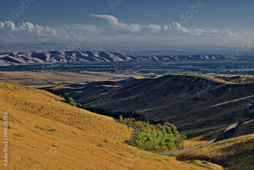 A range of rolling hills with an orchard in the valley. Surroundings of the city of Jalal-Abad, Kyrgyzstan photo