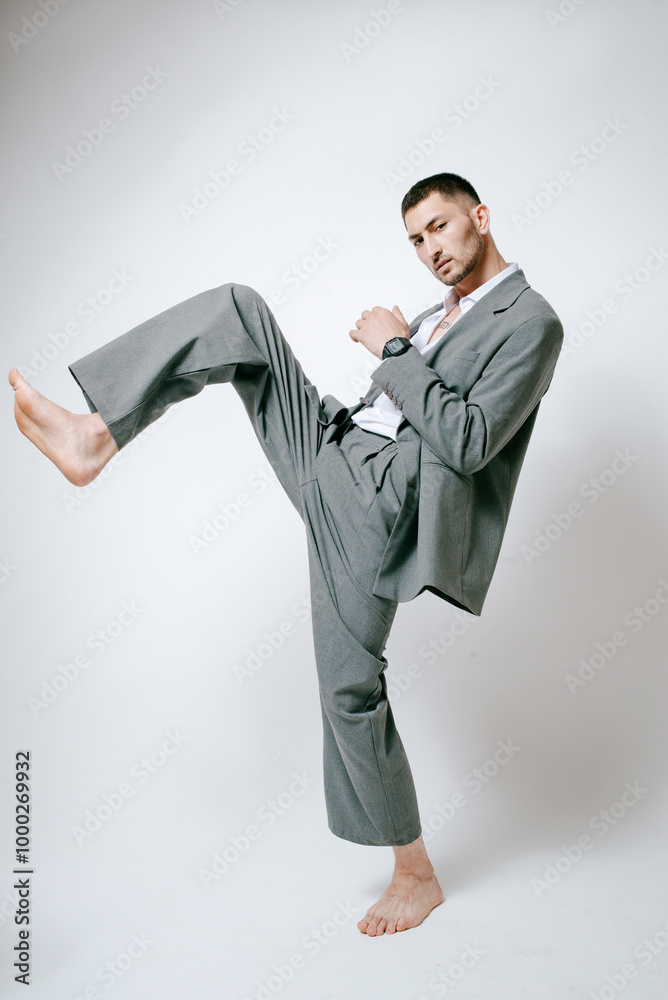 Fashion man model in grey suit, barefoot, shoot in studio Fashion man model in grey suit, barefoot, shoot in studio