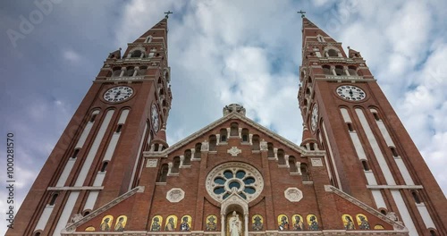 Szeged, Hungary - July 20, 2024: The Votive Church and Cathedral of Our Lady of Hungary. Time-lapse, slide transition. Sunny day, medium cloudy sky. photo