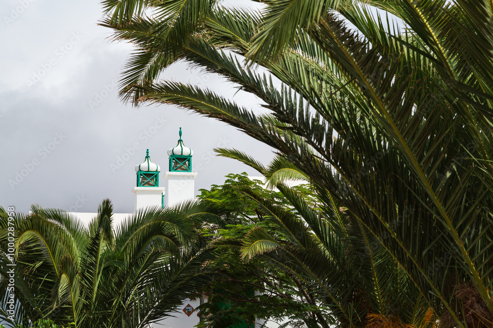 White and green chimneys with palm trees, Playa Blanca, Lanzarote, Spain