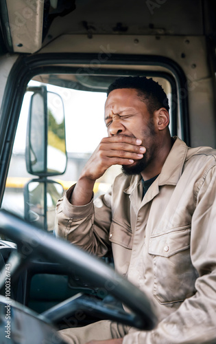 Exhausted Black Truck Driver Yawning While Seated Behind the Wheel During a Long Shift