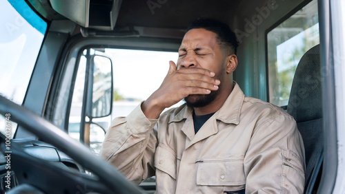 Exhausted Black Truck Driver Yawning While Seated Behind the Wheel During a Long Shift