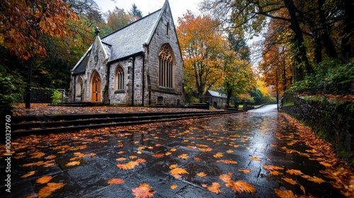 An old stone church surrounded by autumn trees, with fallen leaves covering the steps and soft rain adding to the quiet, moody atmosphere photo