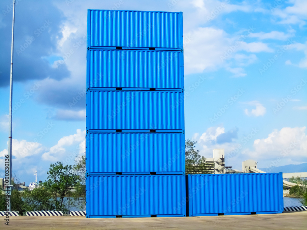 A heavy-duty industrial crane lifting a large blue shipping container at a busy port, set against a backdrop of a bright blue sky and ocean. The scene highlights the efficient cargo handling process A heavy-duty industrial crane lifting a large blue shipping container at a busy port, set against a backdrop of a bright blue sky and ocean. The scene highlights the efficient cargo handling process