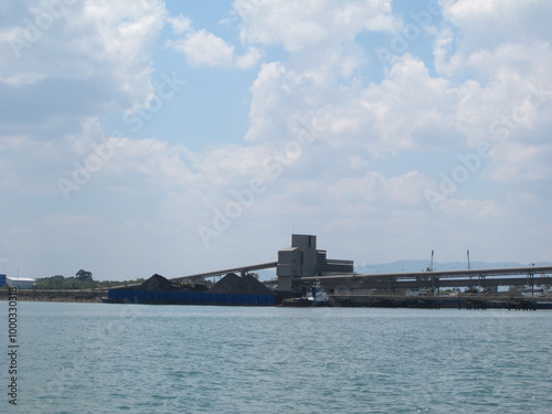 An industrial factory on the coast with a view of the clean ocean and pollution-free air, showcasing an eco-friendly environment