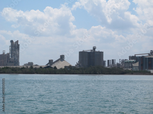 An industrial factory on the coast with a view of the clean ocean and pollution-free air, showcasing an eco-friendly environment