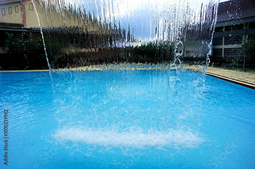 A fountain designed to resemble a waterfall, serving as a decorative feature for a family swimming pool